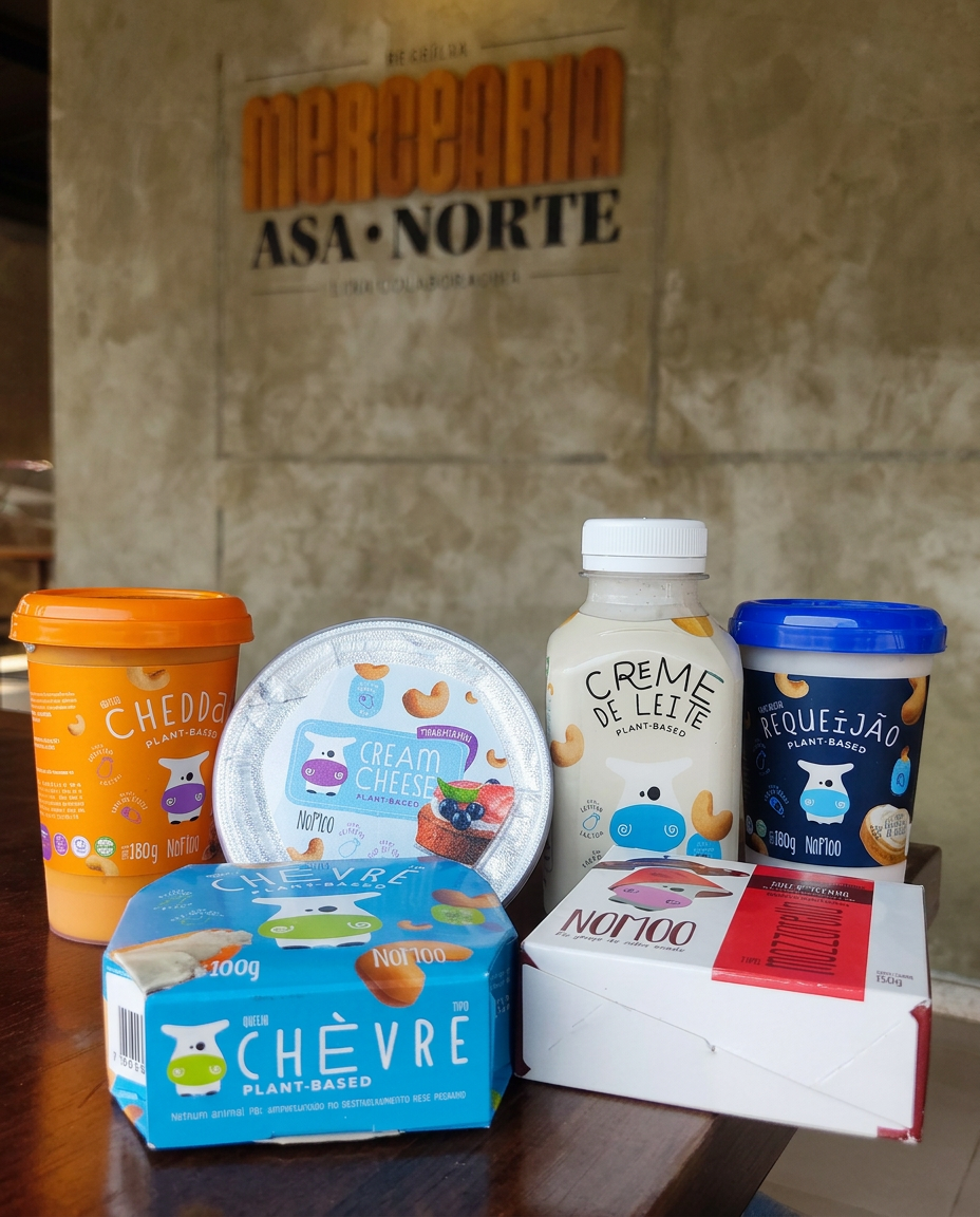 Produtos plant-based da NoMoo sobre a mesa em frente ao letreiro da Mercearia Asa Norte
