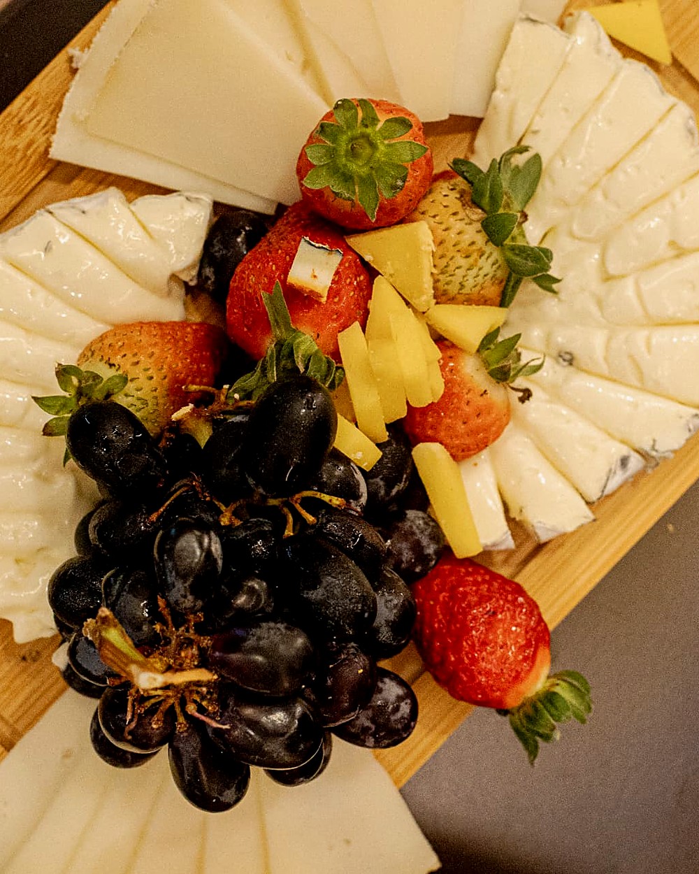 Tábua de queijos artesanais com uvas e morangos para compartilhar