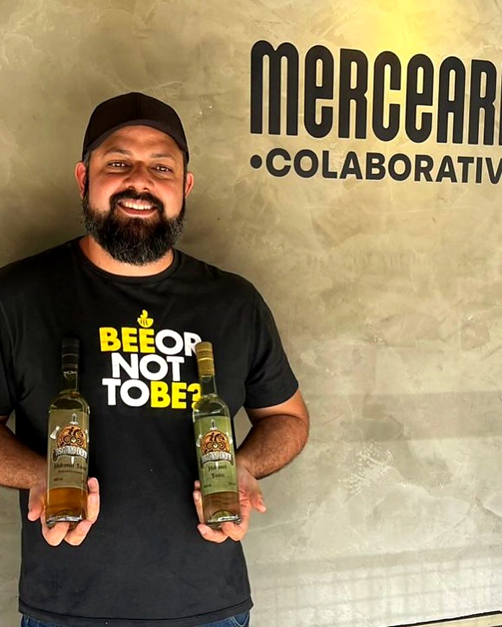 Produtor parceiro com garrafas artesanais na Mercearia Colaborativa